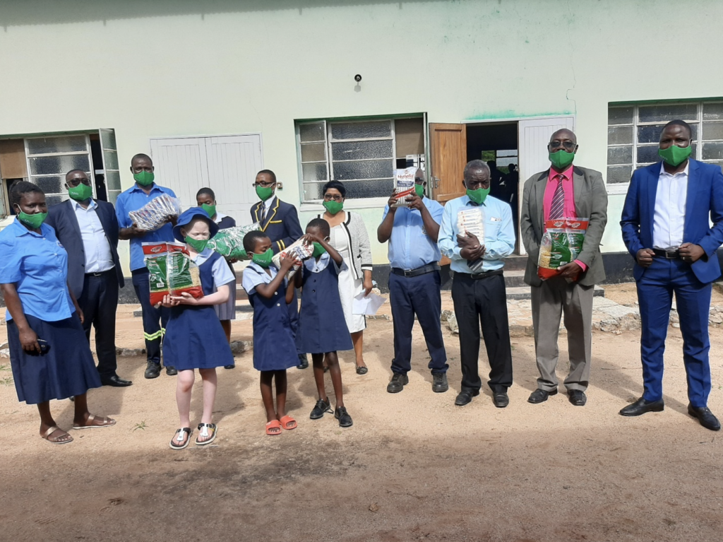 Zuva Petroleum Midlands and Masvingo Regional Managers pose for a picture with students from Copota school.